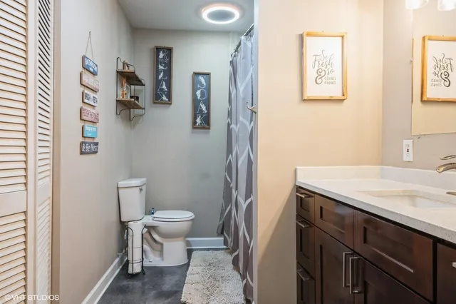 a bathroom with a granite countertop sink a toilet and a mirror