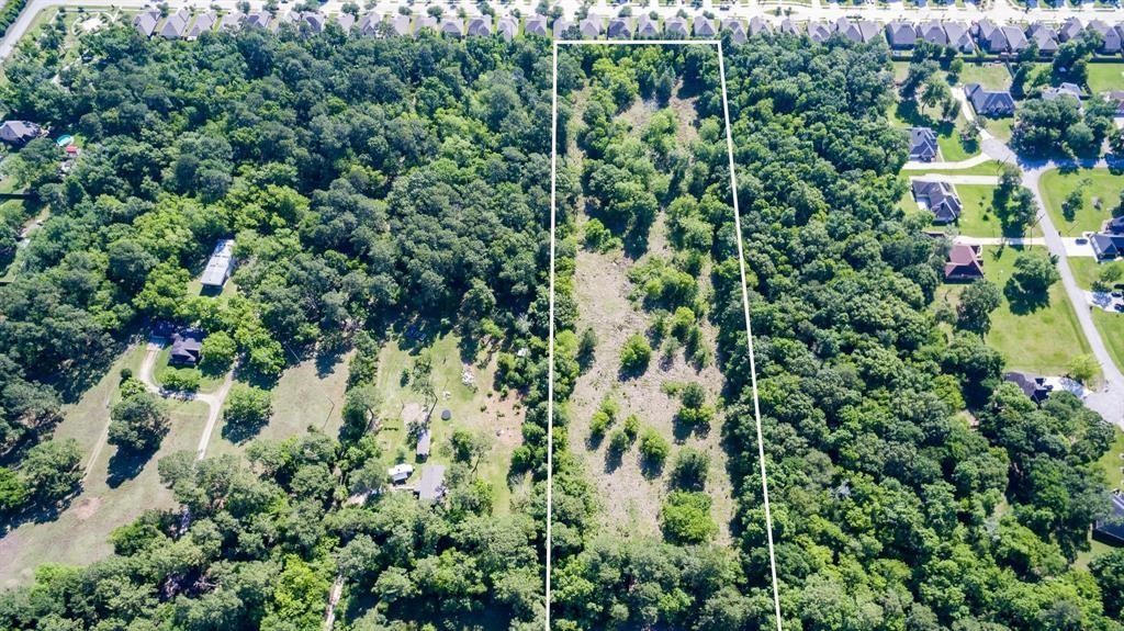 6716 Sjolander Road Baytown, TX 77521 - Photo 20 of 26 This aerial photo showcases a large, undeveloped land parcels surrounded by established neighborhoods, offering a blend of open space and wooded areas, ideal for potential development or a private estate within a suburban setting.