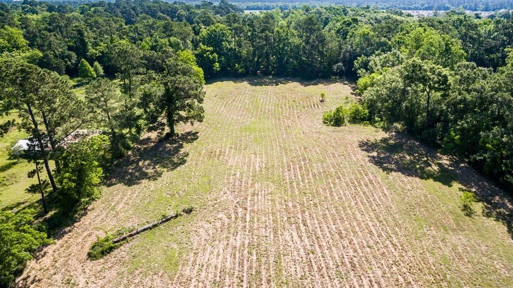 6716 Sjolander Road Baytown, TX 77521 - Photo 21 of 26 This aerial photo showcases a spacious, open plot of land with a mix of cleared areas and surrounding trees, offering a potential site for building a home with natural privacy.