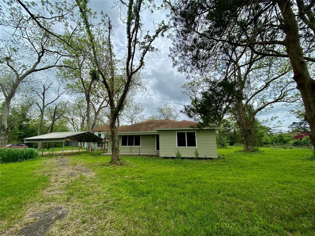 6716 Sjolander Road Baytown, TX 77521 - Photo 24 of 26 Charming single-story home in a lush, green setting with mature trees and a spacious yard. Features a carport and traditional exterior.