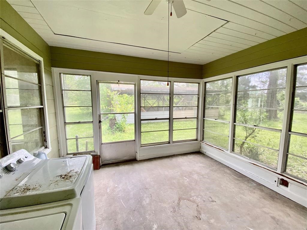 6716 Sjolander Road Baytown, TX 77521 - Photo 9 of 26 Large sunroom with ample natural light from wall-to-wall windows, overlooking a green backyard. The room appears to need some cleaning and possibly updating, but has great potential as a relaxing space or entertaining area.