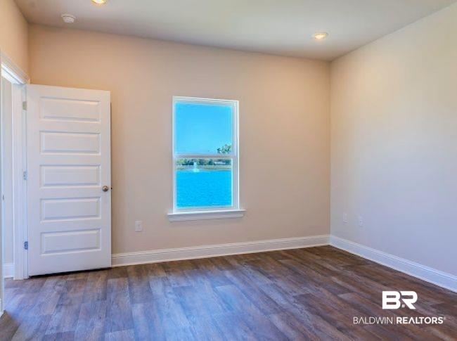 16810 Rocher Court Foley, AL 36535 - Photo 12 of 24 Interior room featuring wood-finish flooring, light-toned walls, and a window presenting a water scene