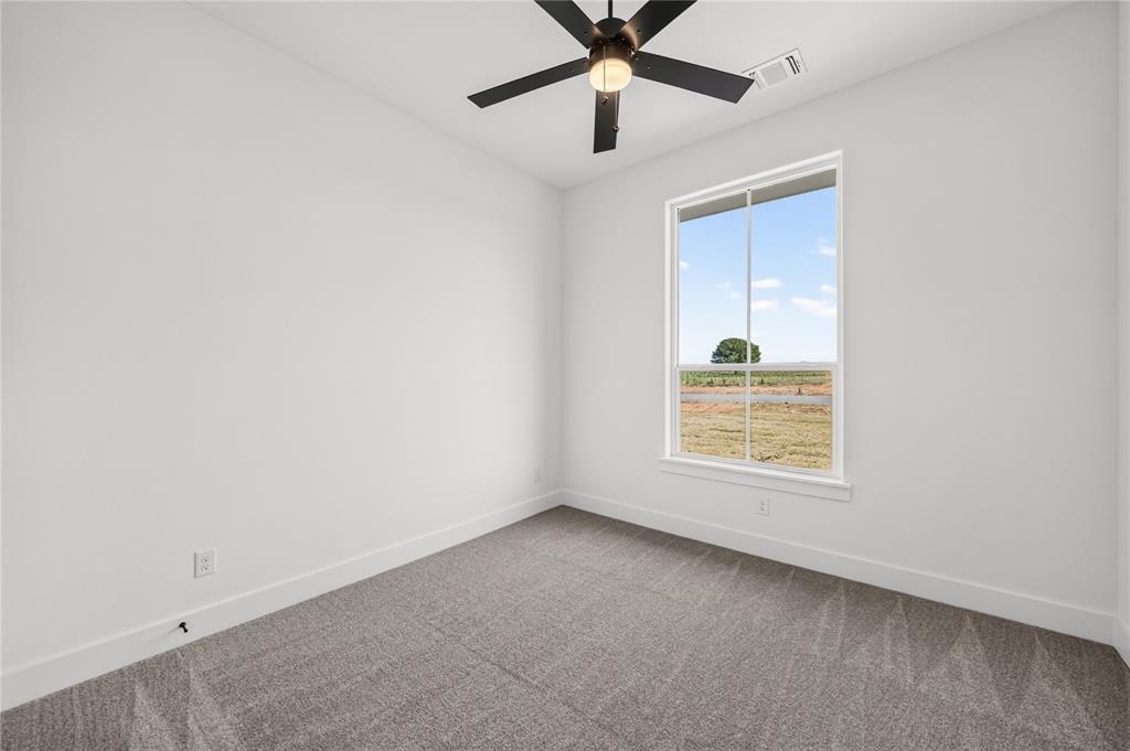 114 Red Bud Road Boyd, TX 76023 - Photo 24 of 32 Carpeted room featuring a large window, neutral wall tones, a ceiling fan, and white trim