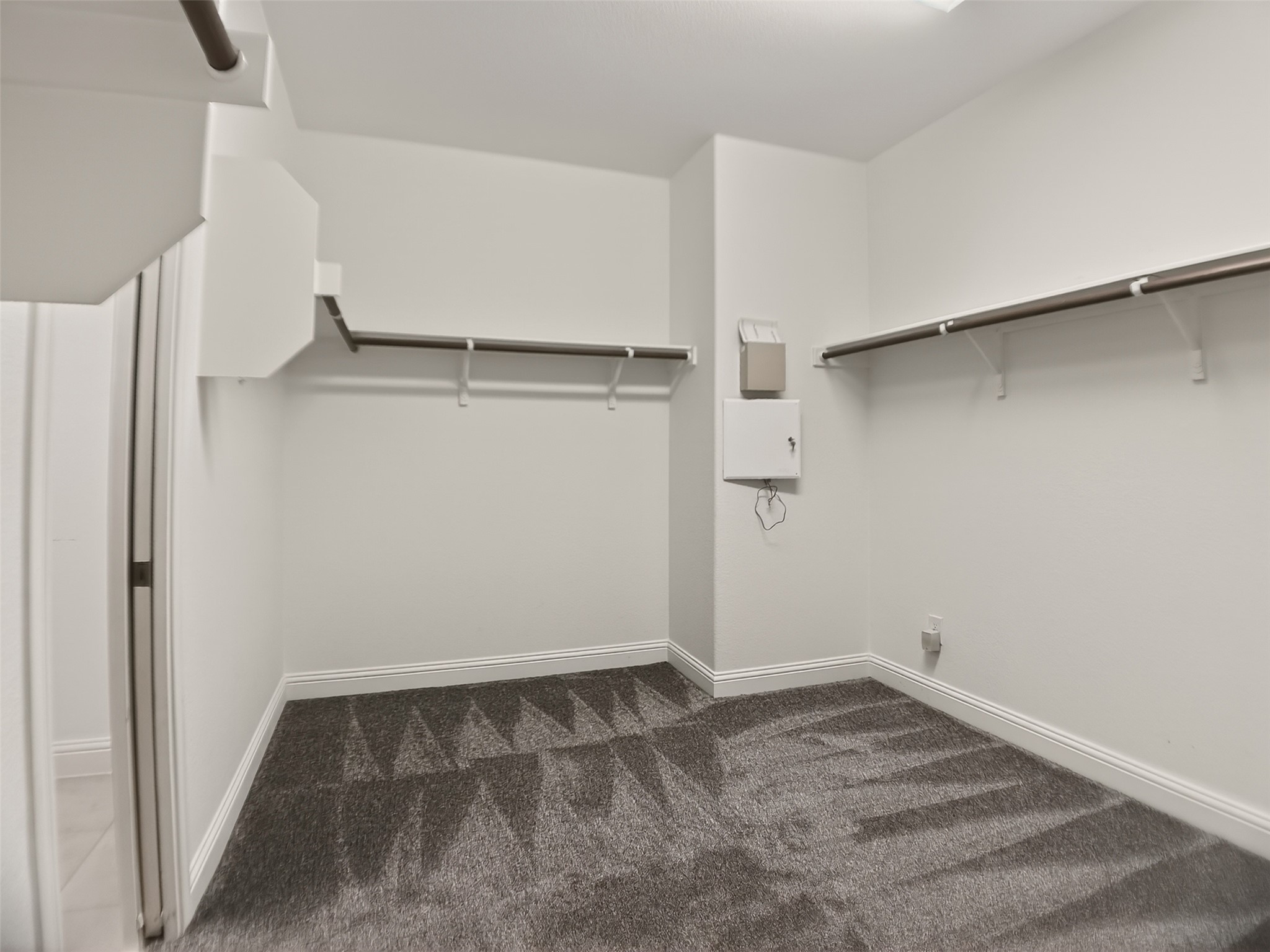 1505 Long Shadow Lane Georgetown, TX 78628 - Photo 16 of 28 Walk-in closet featuring plush gray patterned carpeting, white baseboards, and multiple clothing rods