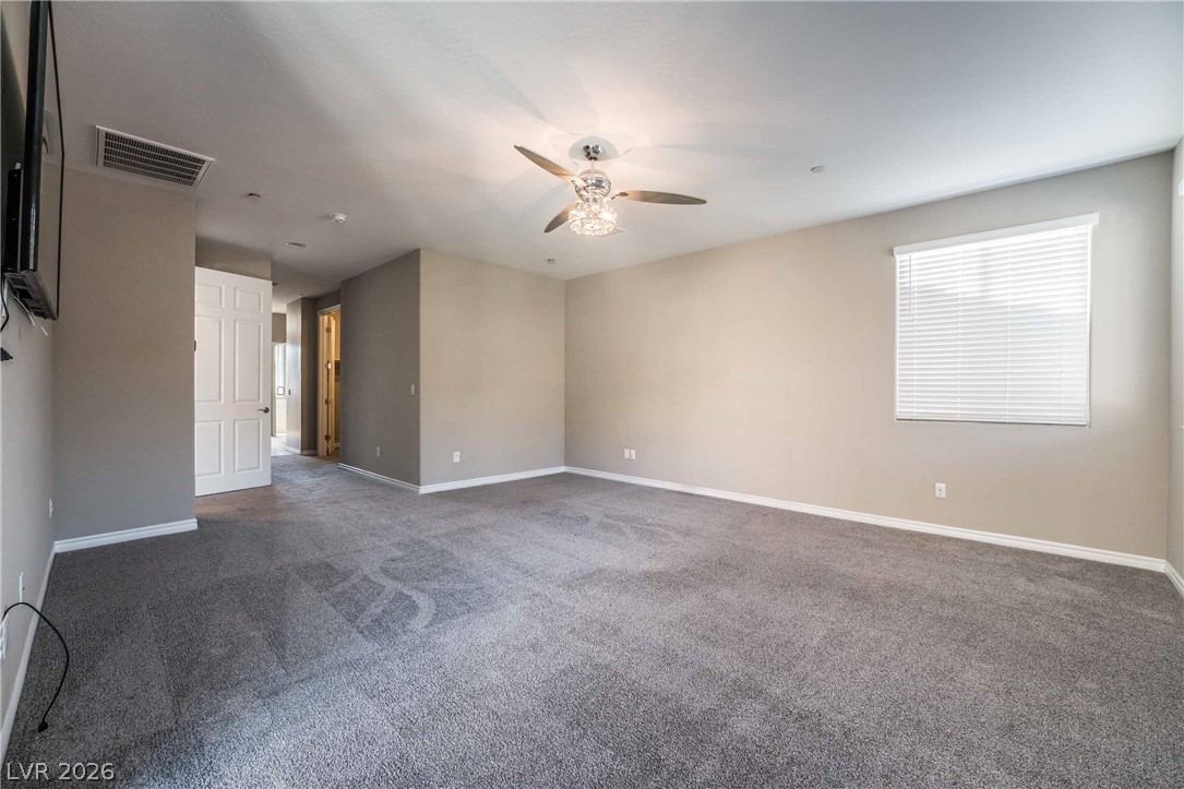 2787 Athens Ridge Drive Henderson, NV 89052 - Photo 15 of 31 A spacious room offers ample natural light and a decorative ceiling fan, providing comfort and style.