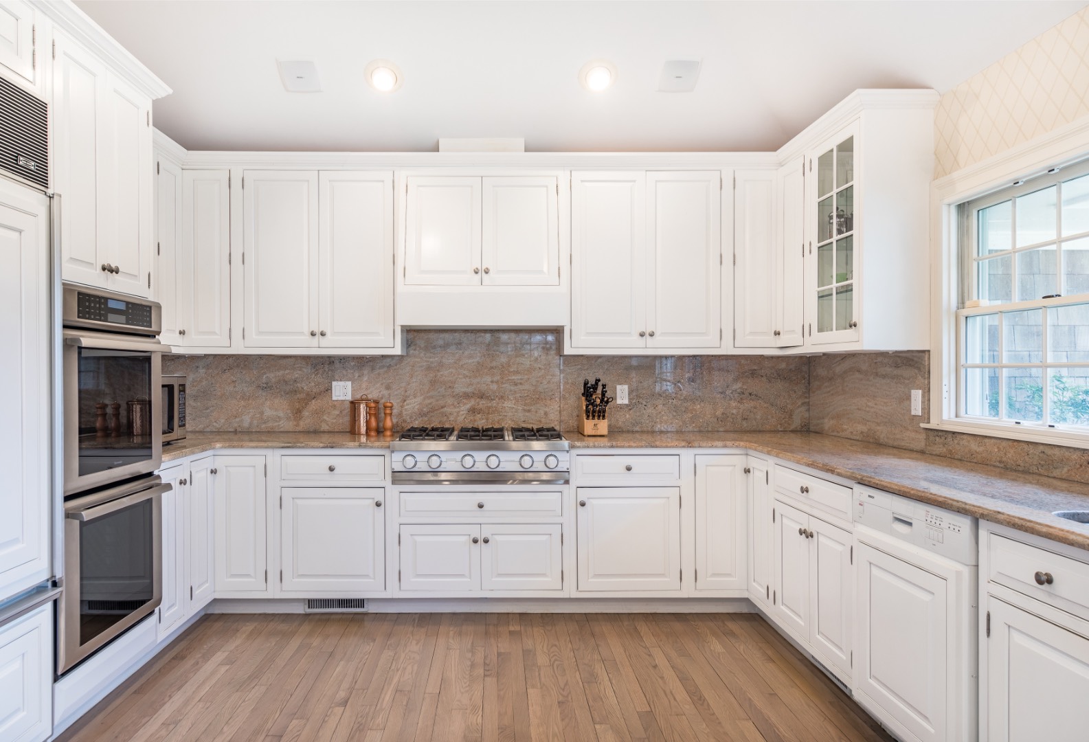 16 Amy's Lane East Hampton, NY 11937 - Photo 5 of 17 a kitchen with granite countertop white cabinets and stainless steel appliances