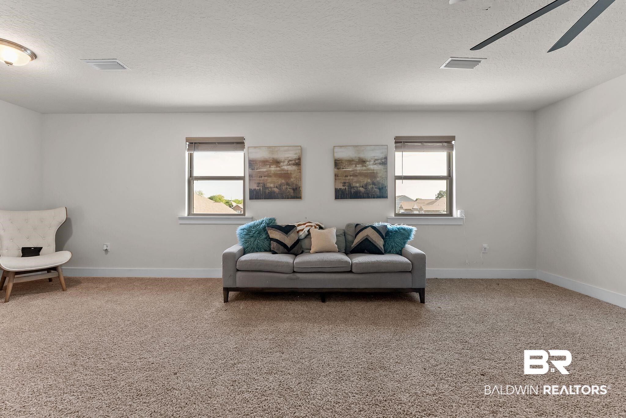 16607 Prado Loop Loxley, AL 36551 - Photo 17 of 46 Spacious room featuring neutral carpeting, white walls, and multiple windows with blinds