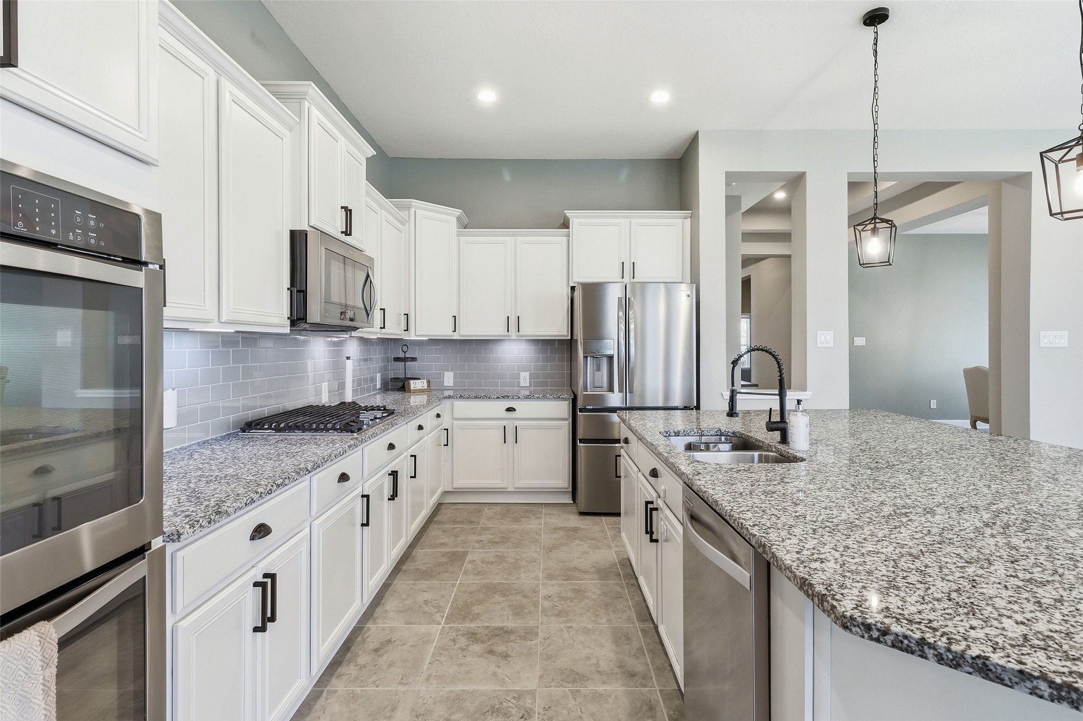 24126 Cane Fields Road Katy, TX 77493 - Photo 12 of 36 Beautifully appointed kitchen enhanced with designer pendant lighting, upgraded cabinet hardware, abundant storage, and an inviting open layout ideal for everyday living and entertaining.