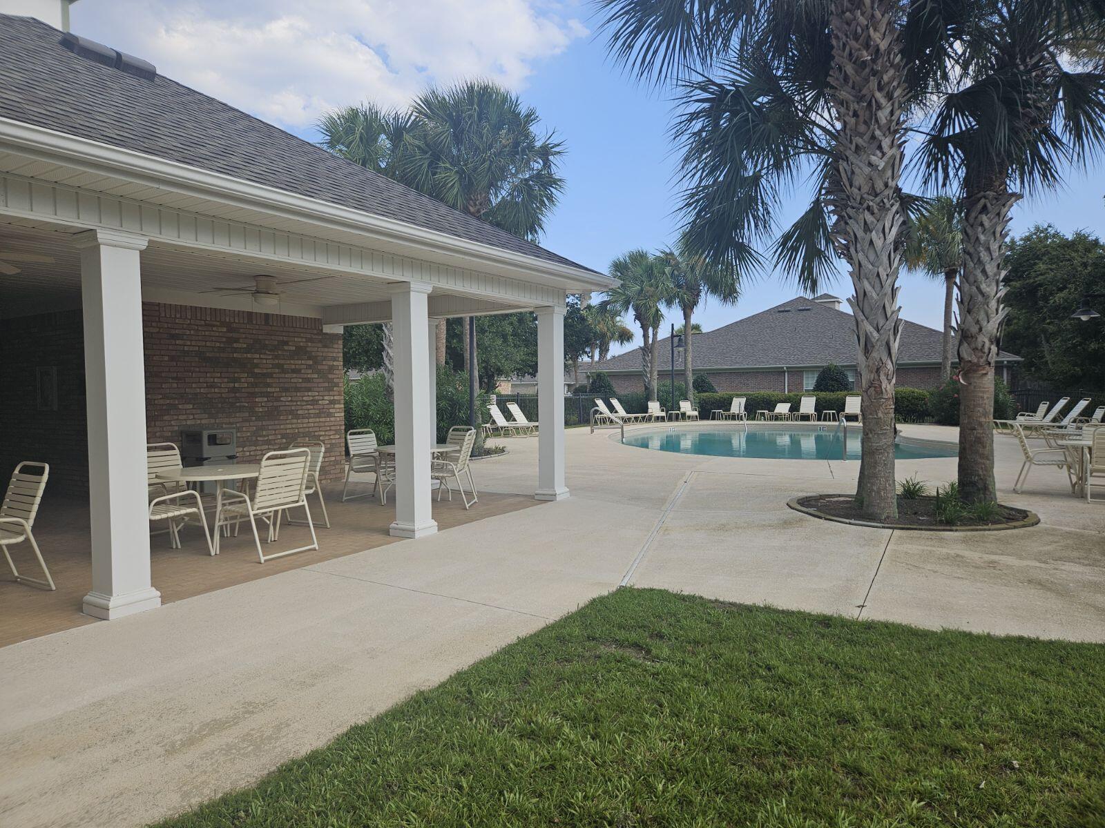 4202 Jade Loop Destin, FL 32541 - Photo 29 of 29 a patio with a table and chairs under an umbrella