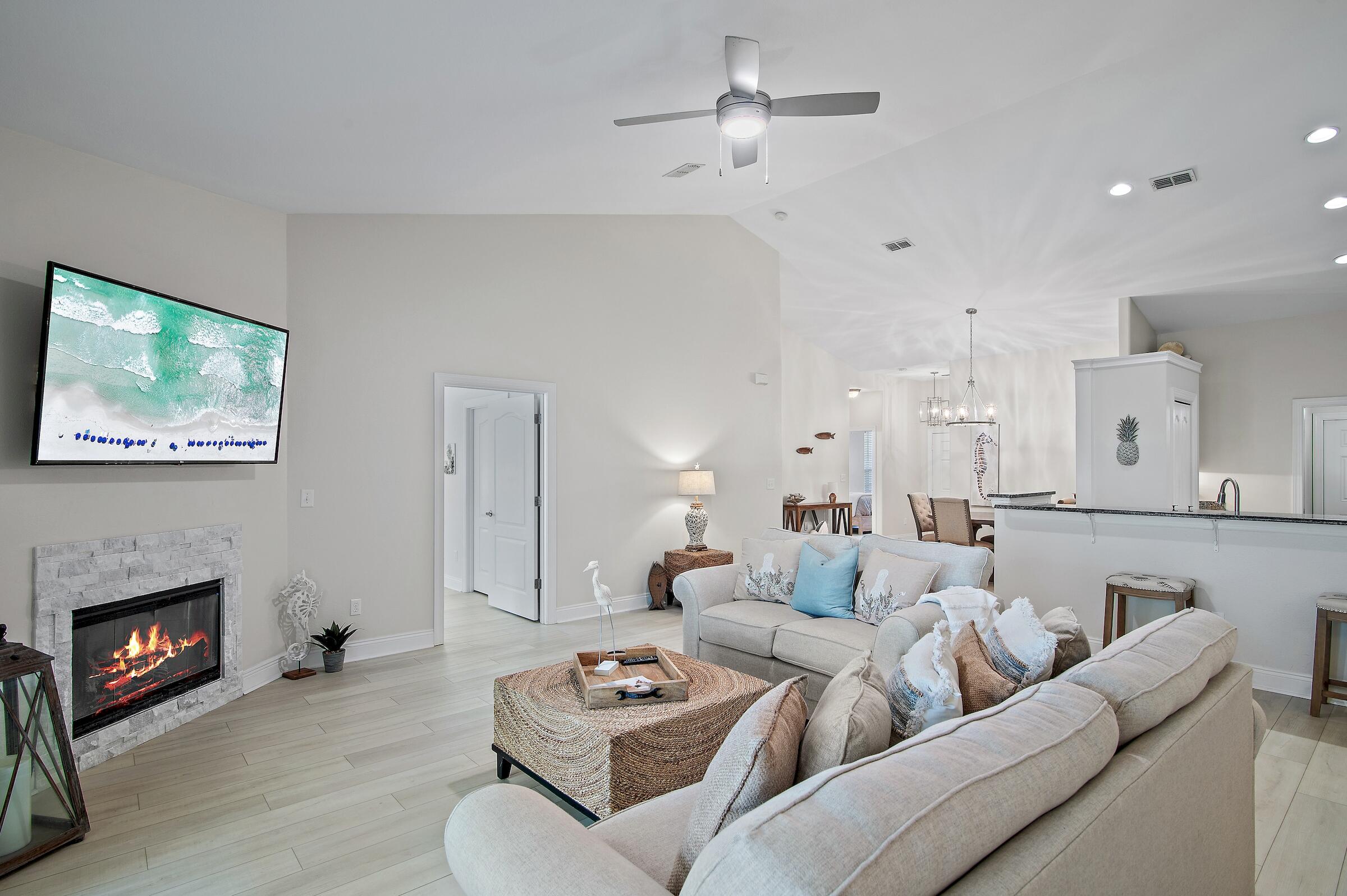 4202 Jade Loop Destin, FL 32541 - Photo 3 of 29 a living room with furniture a fireplace and a ceiling fan