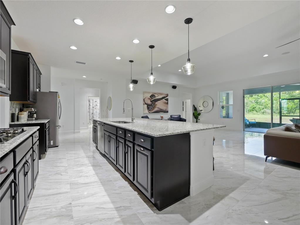 5264 Obsidian Gate Road Mount Dora, FL 32757 - Photo 11 of 49 a kitchen with counter top space a sink stainless steel appliances and windows