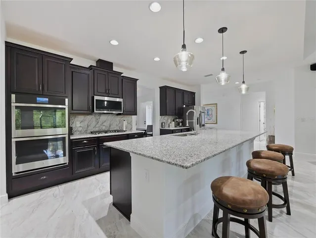 a kitchen with kitchen island granite countertop wooden cabinets and a stove