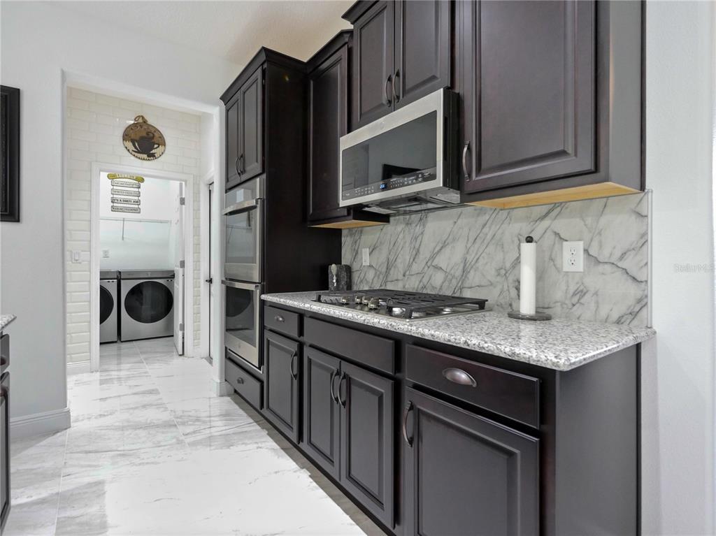 5264 Obsidian Gate Road Mount Dora, FL 32757 - Photo 16 of 49 a kitchen with stainless steel appliances granite countertop a sink stove and refrigerator