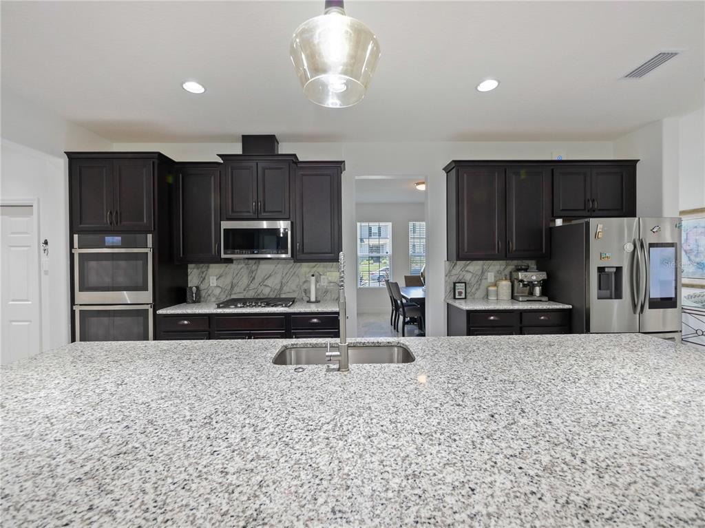 5264 Obsidian Gate Road Mount Dora, FL 32757 - Photo 17 of 49 a large kitchen with stainless steel appliances a refrigerator sink and microwave