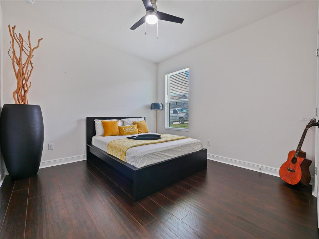 5264 Obsidian Gate Road Mount Dora, FL 32757 - Photo 22 of 49 a bedroom with a bed and wooden floor