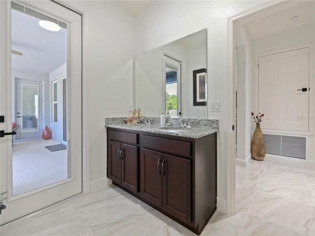 5264 Obsidian Gate Road Mount Dora, FL 32757 - Photo 25 of 49 a spacious bathroom with a granite countertop sink and a mirror