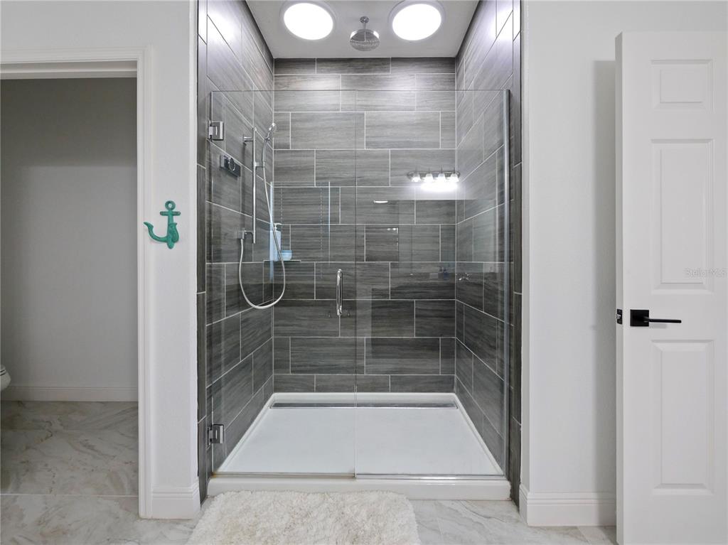 5264 Obsidian Gate Road Mount Dora, FL 32757 - Photo 31 of 49 a bathroom with a glass shower door