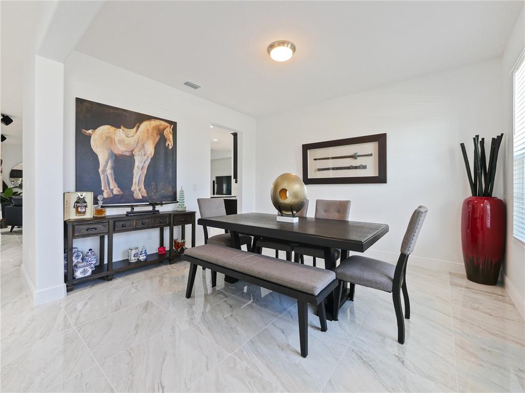 5264 Obsidian Gate Road Mount Dora, FL 32757 - Photo 7 of 49 a dining room with furniture and wooden floor