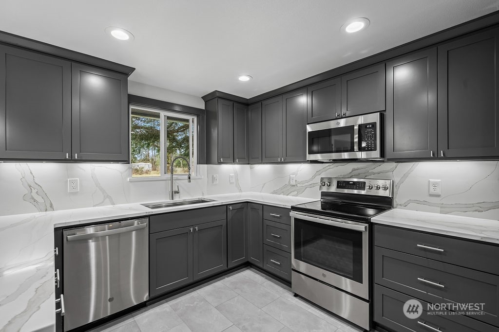 16731 Sargent Road Southwest Rochester, WA 98579 - Photo 14 of 34 a kitchen with a sink stainless steel appliances and cabinets