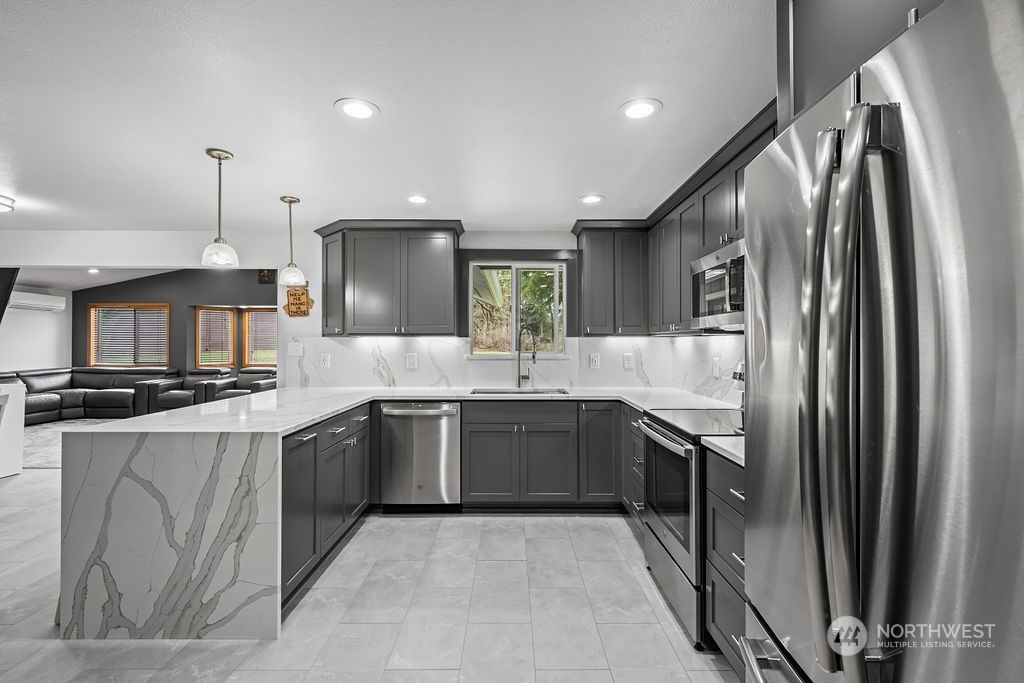 16731 Sargent Road Southwest Rochester, WA 98579 - Photo 15 of 34 a large kitchen with stainless steel appliances granite countertop a sink and a refrigerator