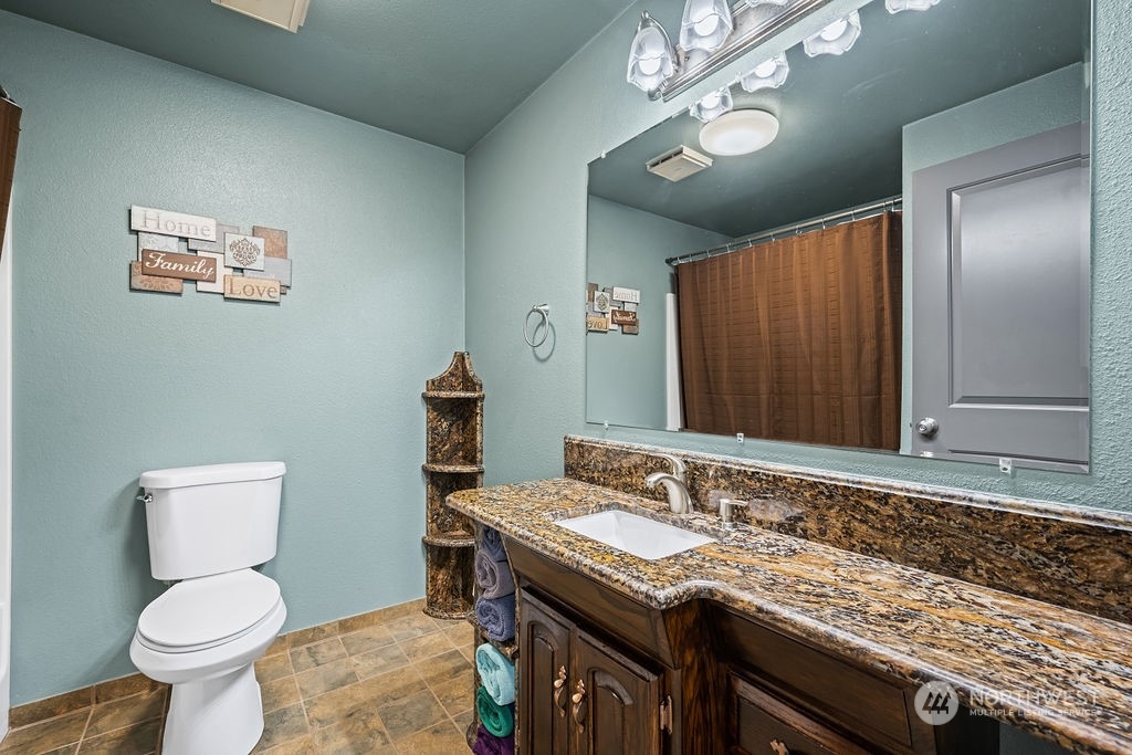 16731 Sargent Road Southwest Rochester, WA 98579 - Photo 18 of 34 a bathroom with a granite countertop toilet sink and mirror