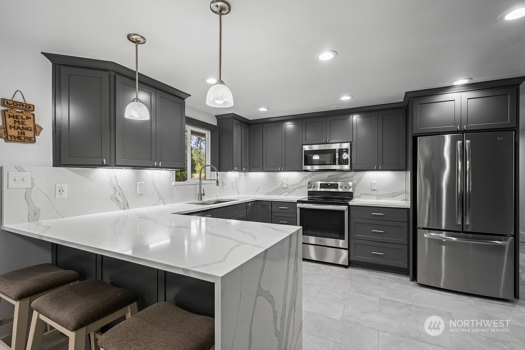 16731 Sargent Road Southwest Rochester, WA 98579 - Photo 10 of 34 a kitchen with a center island and stainless steel appliances