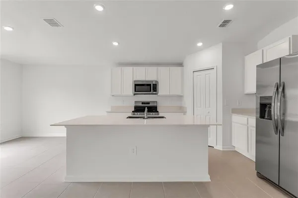 a kitchen with stainless steel appliances a refrigerator sink and microwave