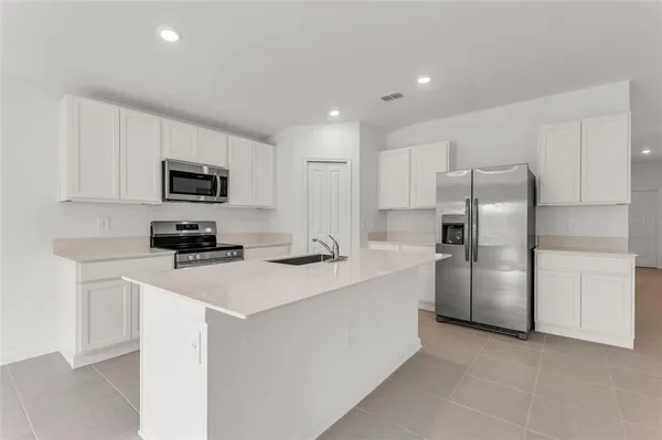 a kitchen with stainless steel appliances a sink stove and refrigerator