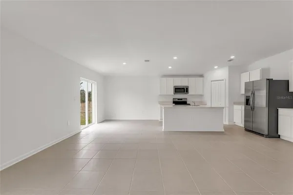 a view of an empty room with a kitchen