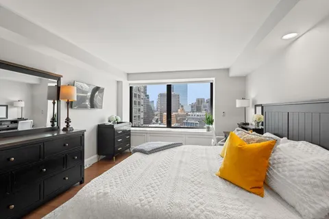 a bedroom with a bed and large windows