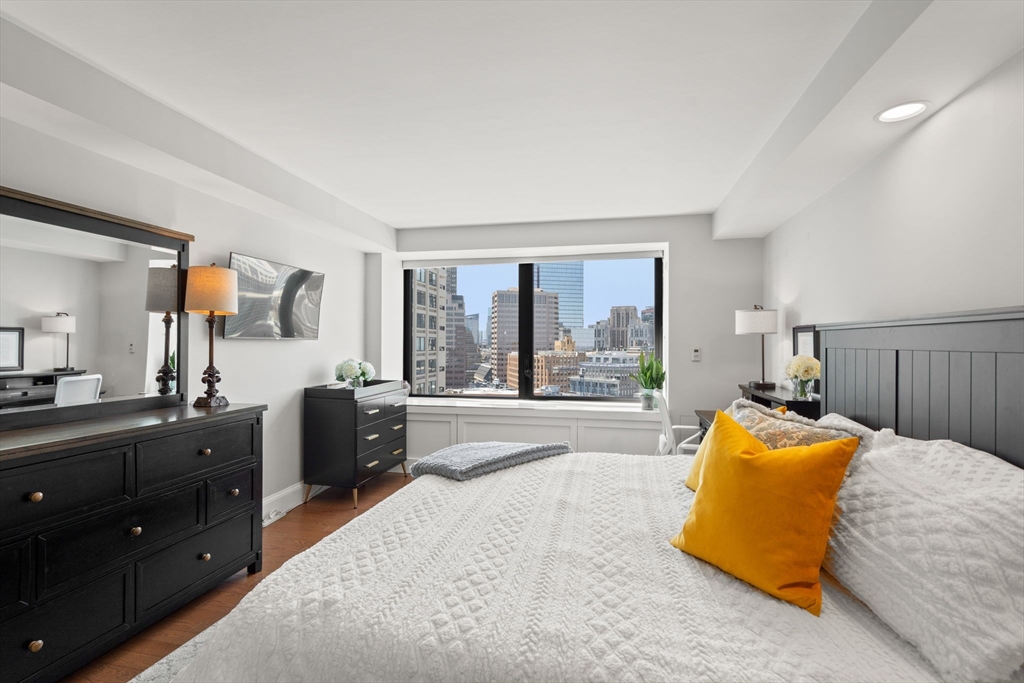 85 East India Row, Unit 20G Boston, MA 02110 - Photo 22 of 37 a bedroom with a bed and large windows
