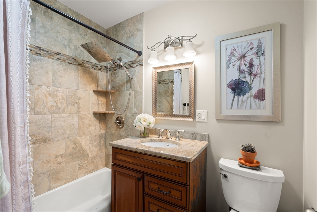 85 East India Row, Unit 20G Boston, MA 02110 - Photo 26 of 37 a bathroom with a granite countertop sink a toilet and a bathtub