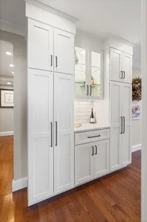 a kitchen with white cabinets and white appliances