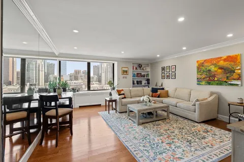a living room with furniture large window and a table