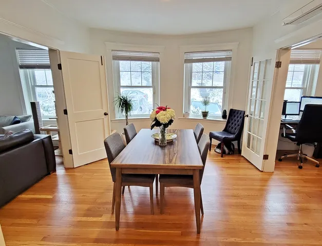 a view of a a dining room with furniture window and wooden floor