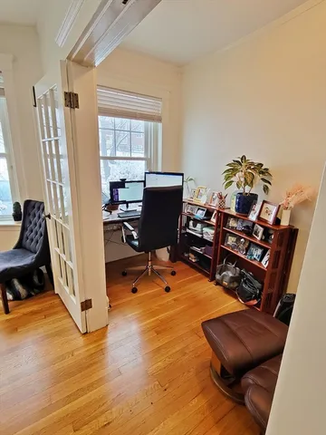 a view of a livingroom with workspace and a window