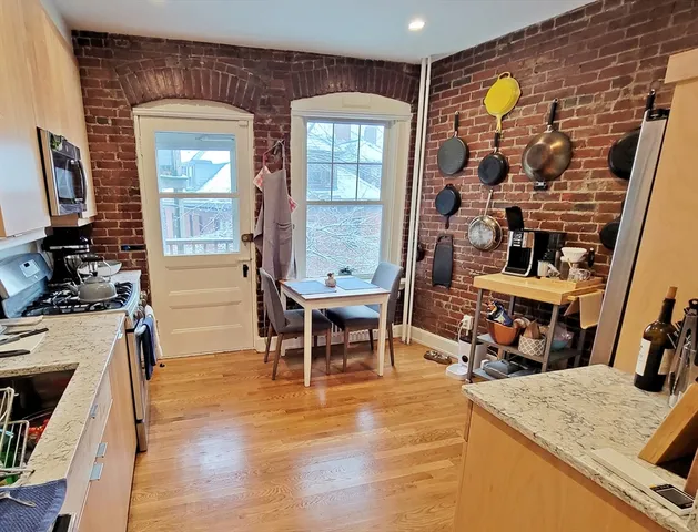 a dining room with wooden floor and a chandelier