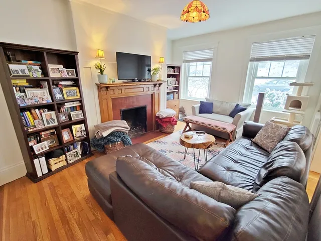 a living room with furniture a fireplace and a flat screen tv