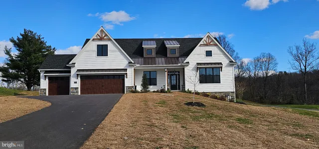 a front view of a house with outdoor seating and flowers