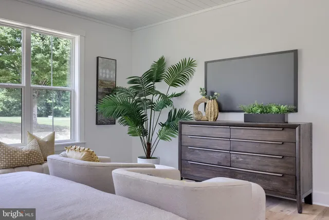 a view of a dining room and livingroom with furniture wooden floor a chandelier