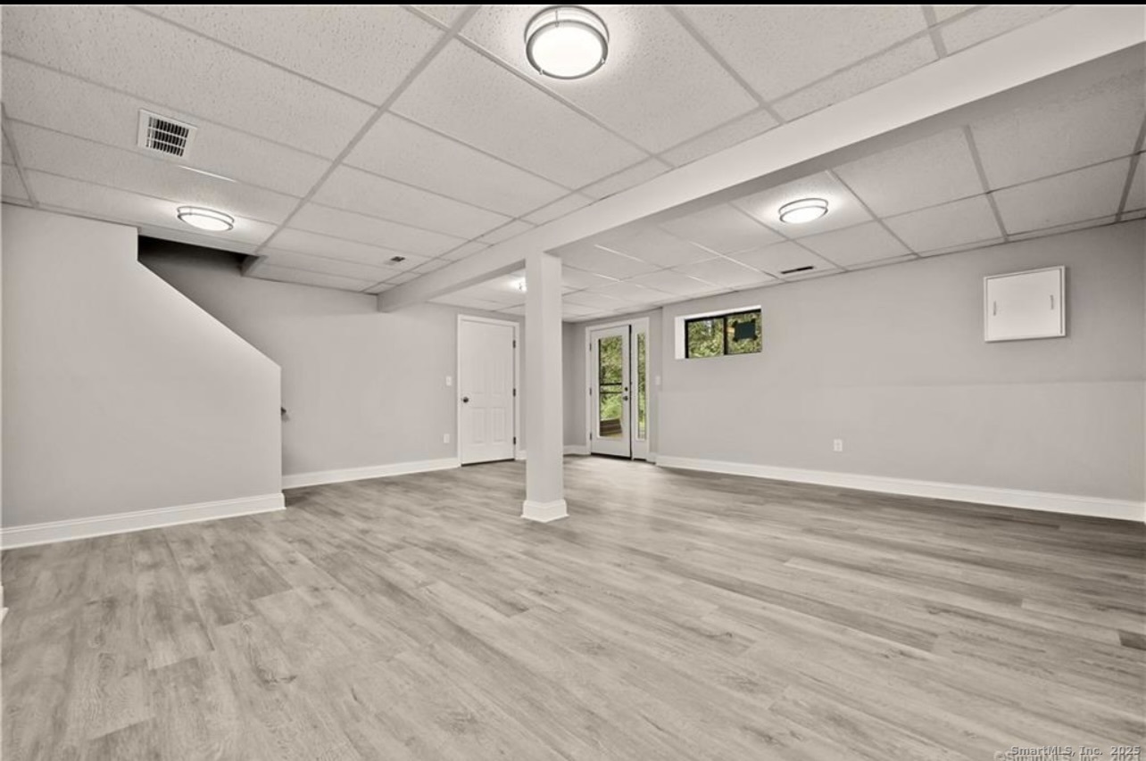 383 Sequoia Lane, Unit A Stratford, CT 06614 - Photo 12 of 17 an empty room with wooden floor and windows