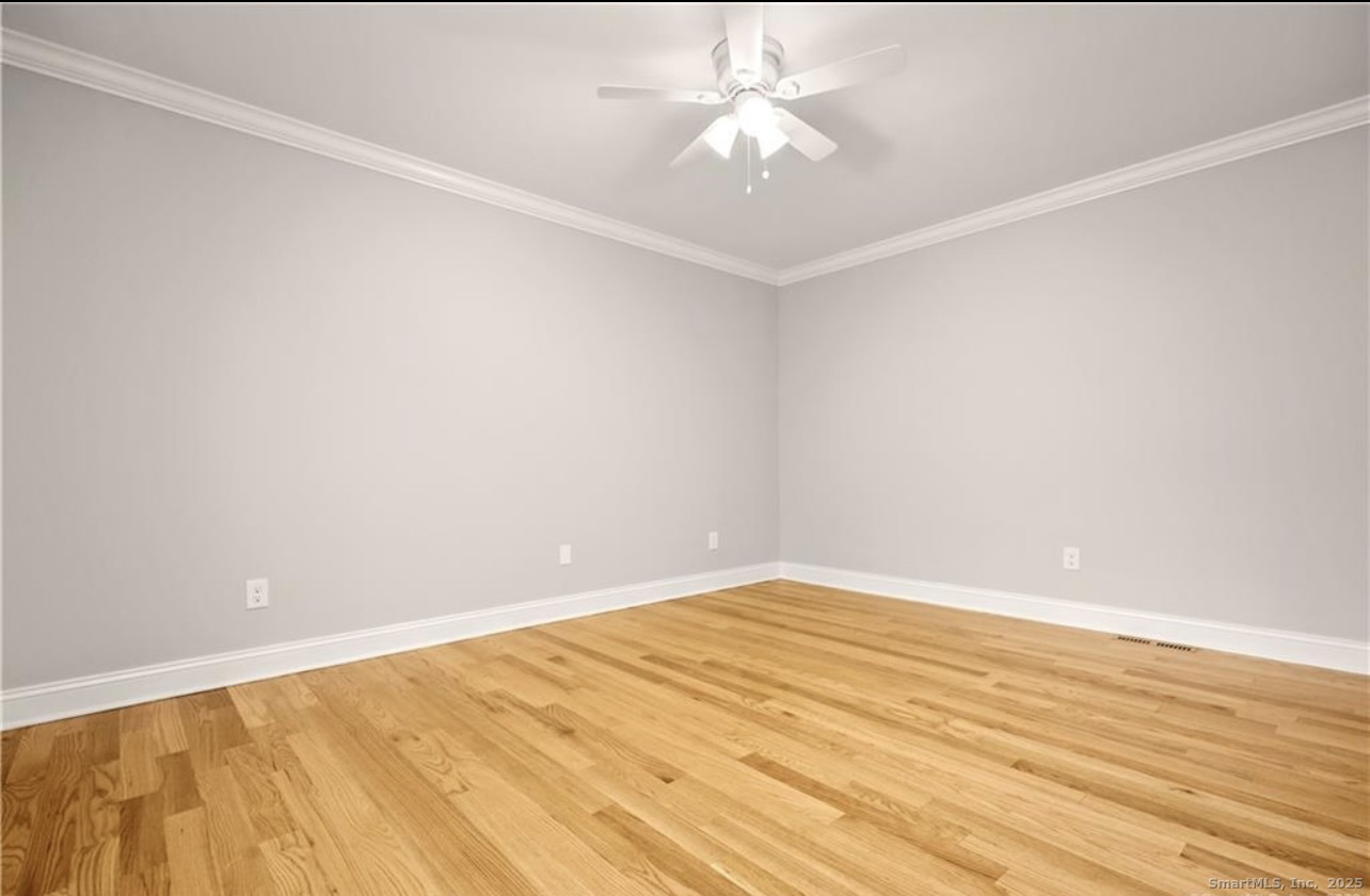 383 Sequoia Lane, Unit A Stratford, CT 06614 - Photo 10 of 17 an empty room with wooden floor and fan
