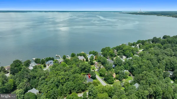 an aerial view of residential house with outdoor space and trees all around