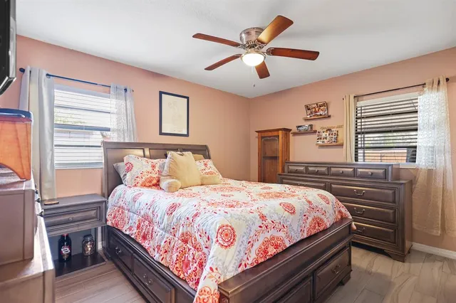 a bedroom with a bed next to a window and a chandelier