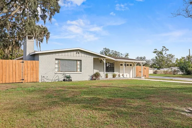 a view of a house with a big yard and a large tree