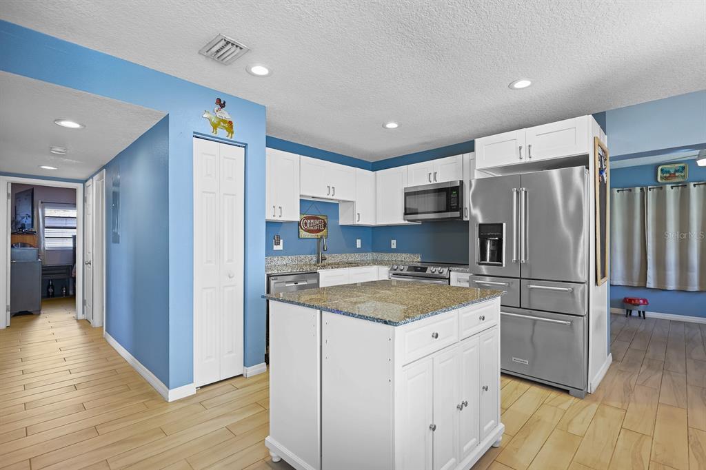 1001 Alpine Drive Brandon, FL 33510 - Photo 7 of 29 a kitchen with a refrigerator a stove top oven and wooden floor