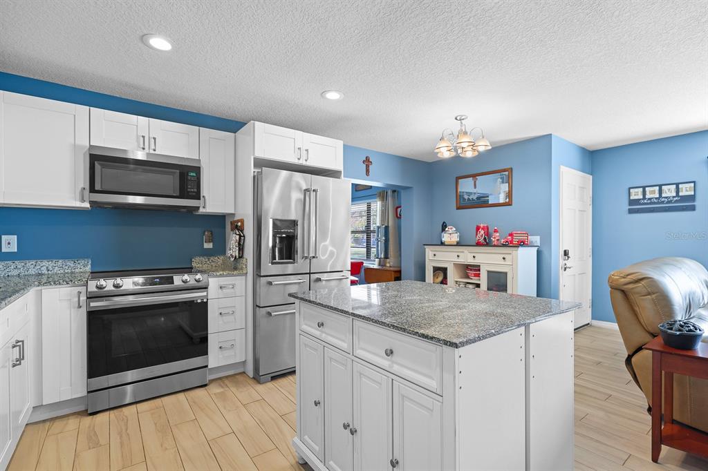 1001 Alpine Drive Brandon, FL 33510 - Photo 10 of 29 a kitchen with stainless steel appliances granite countertop a stove refrigerator and a microwave