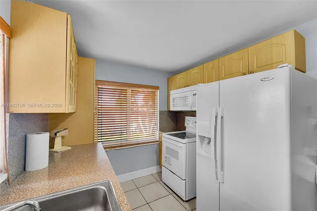 a kitchen with a refrigerator and a sink
