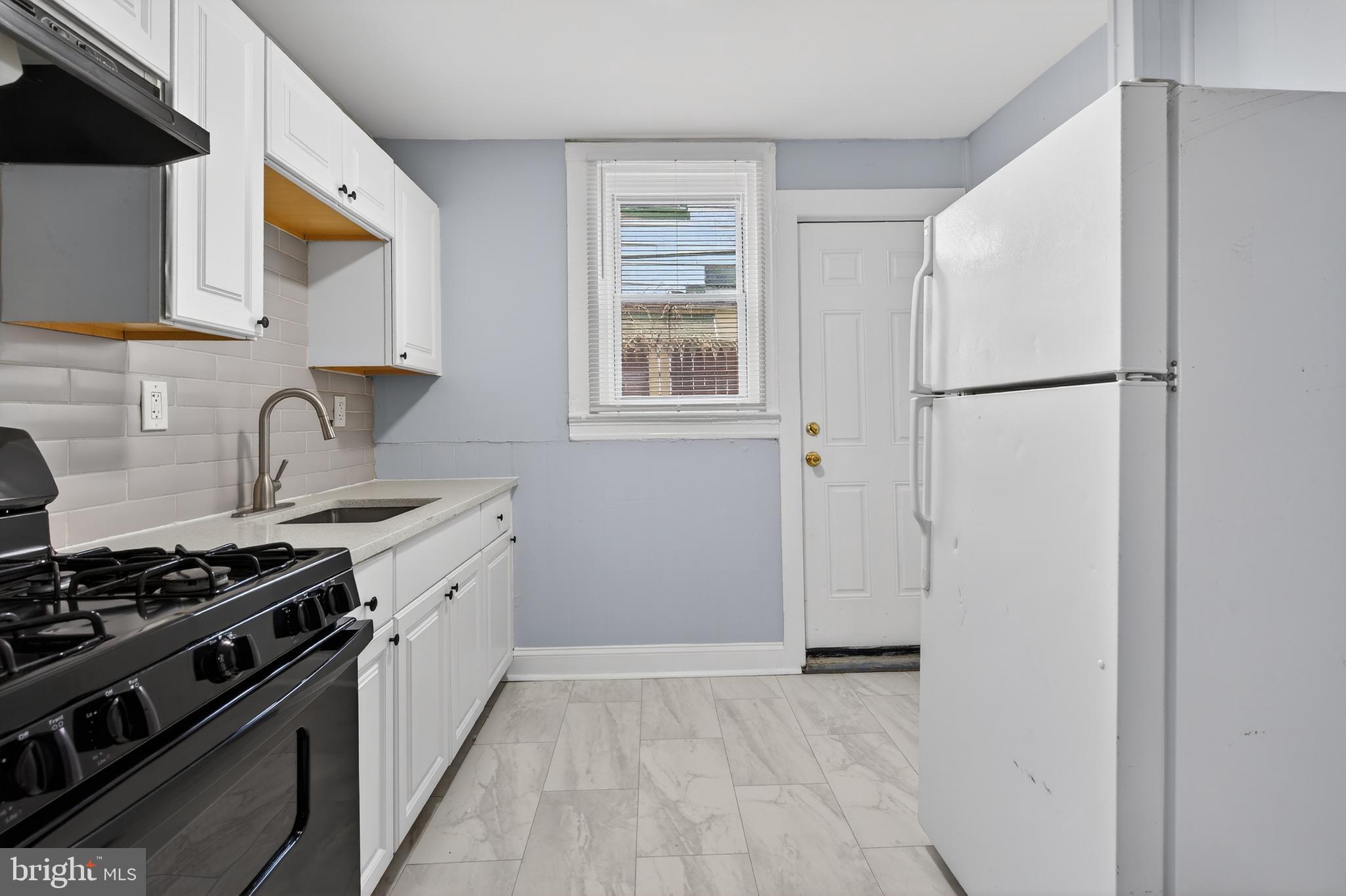 3039 Gransback Street Philadelphia, PA 19134 - Photo 5 of 10 a kitchen with stainless steel appliances a refrigerator stove and sink