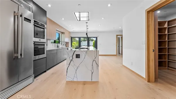 a kitchen with stainless steel appliances kitchen island granite countertop a refrigerator and a stove top oven